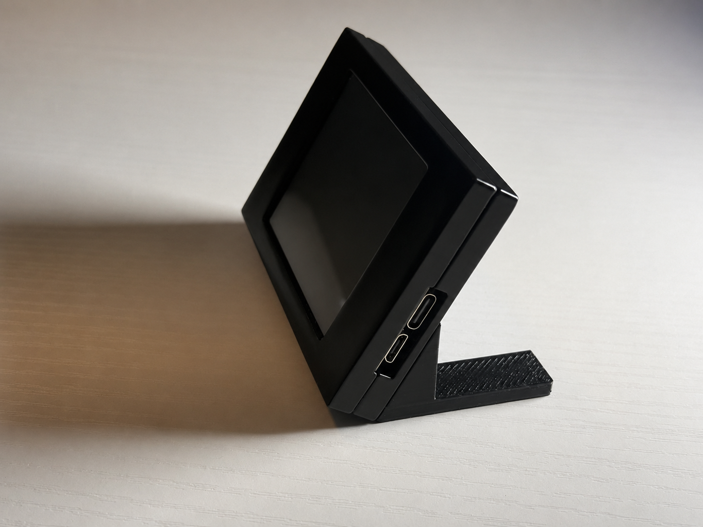 Side view of the desktop ticker enclosure and connection ports