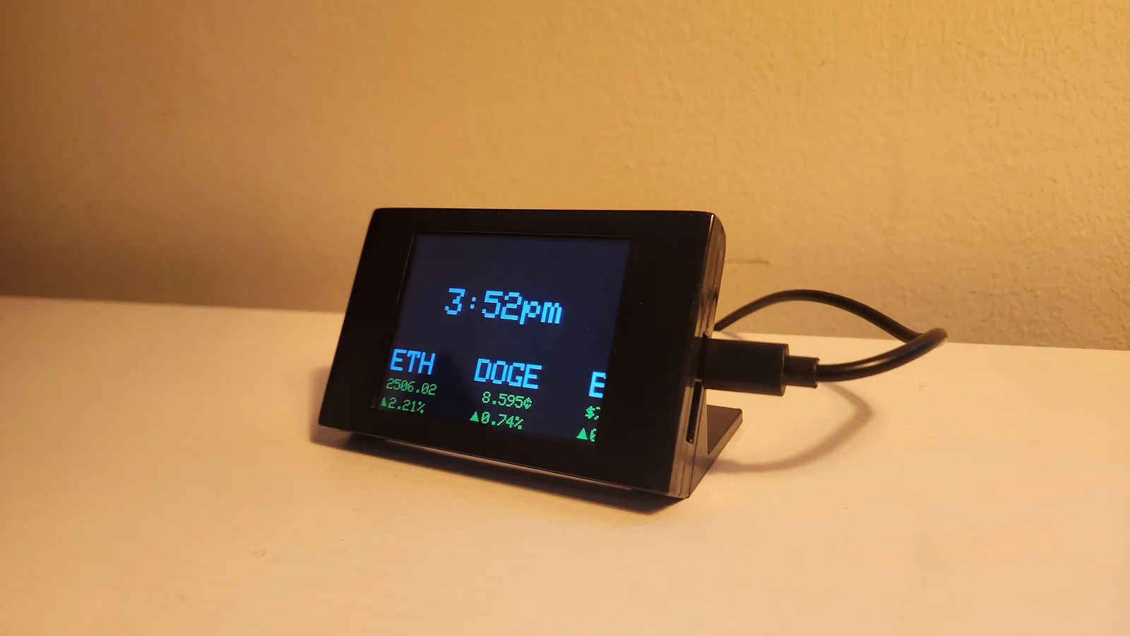 Angled view of the desktop ticker showing a live crypto watchlist