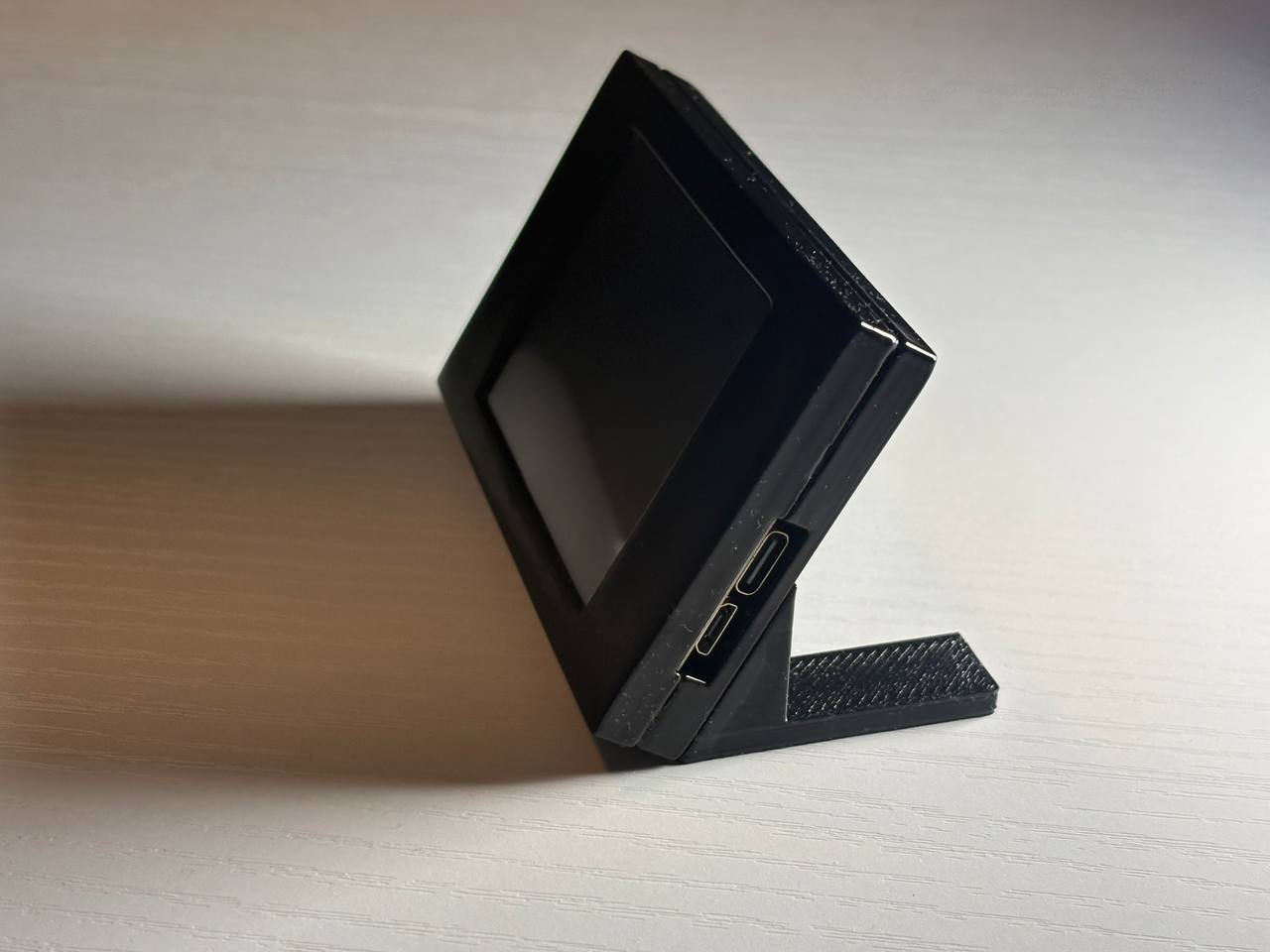 Side view of the desktop ticker enclosure and connection ports